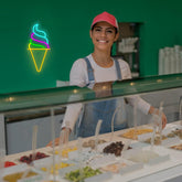 Person in a ice cream shop with a neon ice cream cone sign in the background