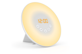 Round alarm clock with a yellow light on a white background