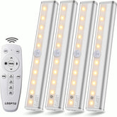 Set of four LED stick-on lights with a remote control on a white background