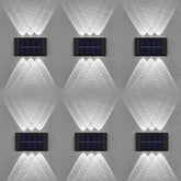Six solar-powered wall lights on a textured gray wall.