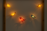 String lights shaped like dinosaurs on a wall