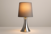 Table lamp with a brown shade and silver base on a neutral background