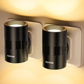 Two black AUVON night lights attached to a wall socket with warm glow.