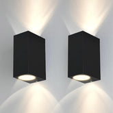 Two black square wall lights on a white wall