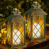 Two decorative lanterns with glowing lights on a wooden surface with a natural background.