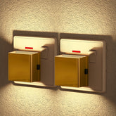 Two gold night lights on a textured wall.