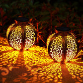 Two illuminated solar lanterns with intricate designs on a dark background