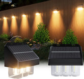 Two solar-powered outdoor lights with a wooden wall and plants in the background.