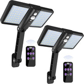 Two solar flood lights with remote controls on a white background