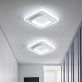 Two square ceiling lights on a white ceiling with a room corner in the background.