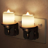 Two wall-mounted candle lights with glowing candles on a neutral background