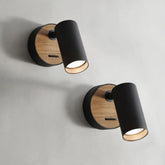 Two wall-mounted lights with black cylindrical shades and wooden bases on a gray background