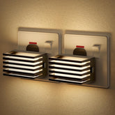 Two wall-mounted light fixtures on a textured wall.