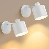 Two white wall-mounted spotlights on a beige wall.