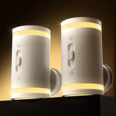 Two white wall lights with a warm glow on a dark background