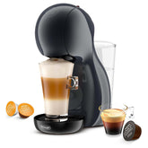 Nescafe Dolce Gusto coffee machine with a glass of cappuccino and capsules on a white background