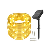 Solar-powered LED string light set with coil of lights, solar panel, and stakes on a white background