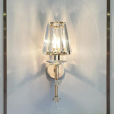 Wall-mounted lamp with crystal shade on a white wall