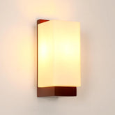 Wall-mounted light fixture with a warm glow on a plain wall.