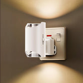Wall-mounted night light switch with a warm glow on a brown wall.