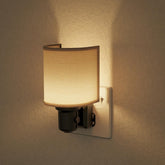 Wall-mounted night light with a beige shade on a beige wall