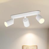 White ceiling light fixture with three cylindrical lights on a neutral background