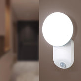White motion sensor light on a wall with a blurred background