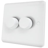 White wall-mounted light switch with two round buttons on a white background