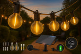 String of glowing outdoor lights with a solar panel and accessories on a wooden surface.