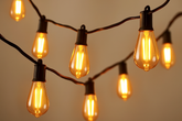 String of illuminated light bulbs against a neutral background