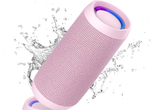 Pink Bluetooth speaker with water splashes on a white background