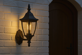 Decorative outdoor wall light fixture on a brick wall