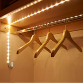 Wireless PIR motion sensor LED strip light installed in a wardrobe