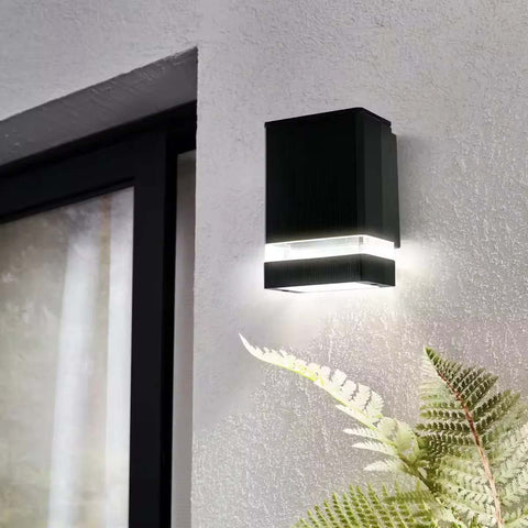 Outdoor wall light casting light on a garden feature at night

