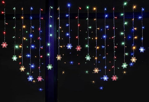 Glowing snowflakes across window curtain


