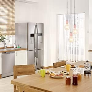 Modern kitchen with stainless steel refrigerator, wooden table, and various items on the table.