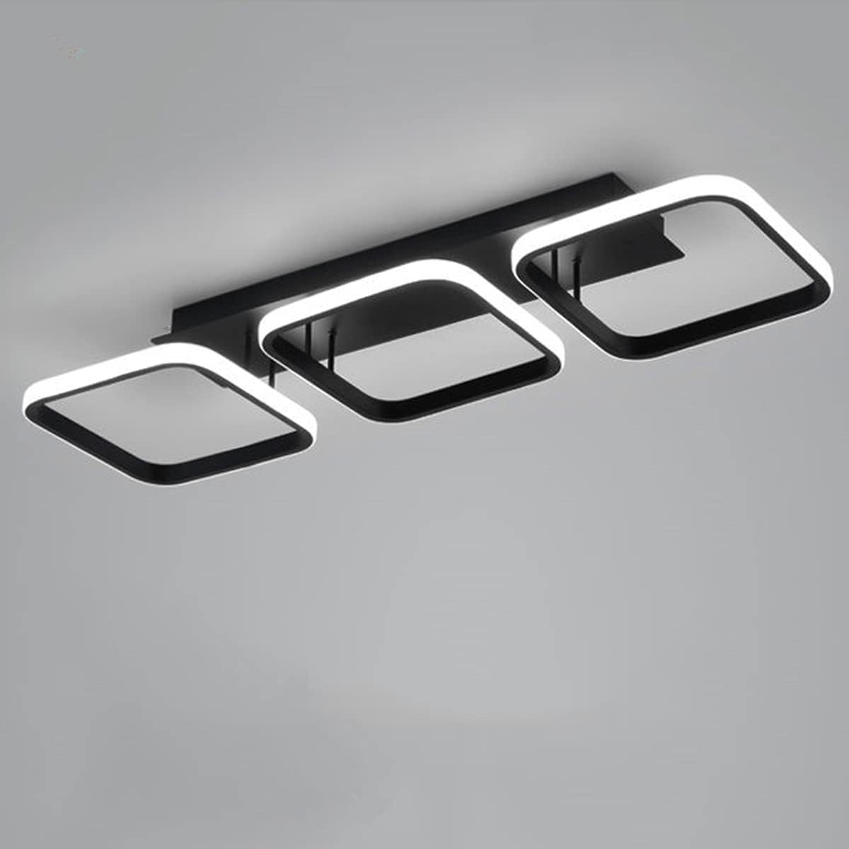 Modern ceiling light fixture with three square panels on a gray background