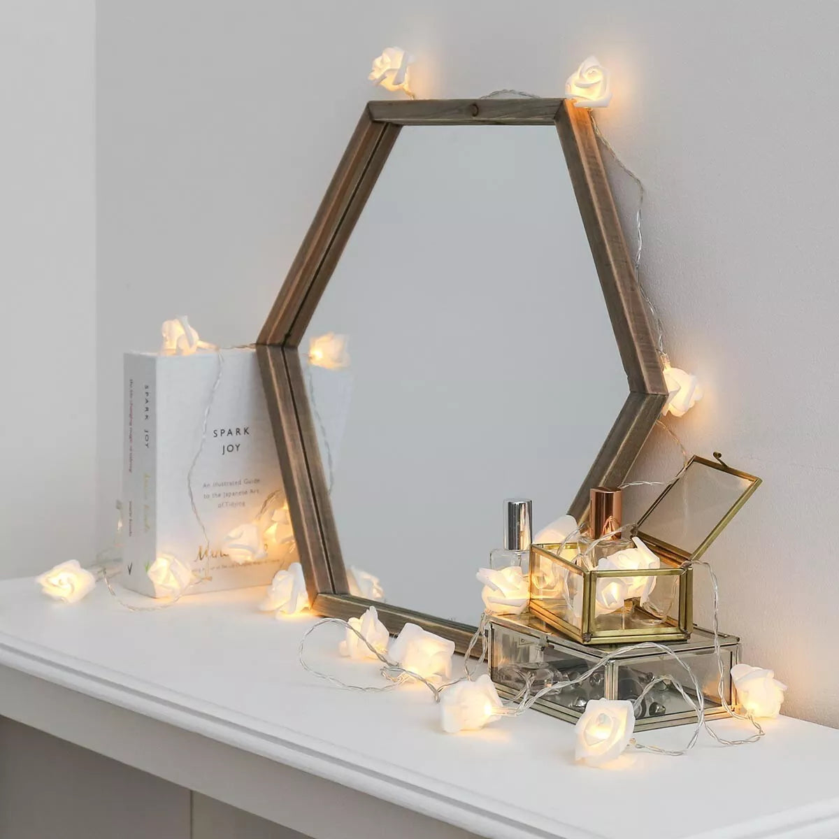 Clear cable rose fairy lights wrapped around a mirror

