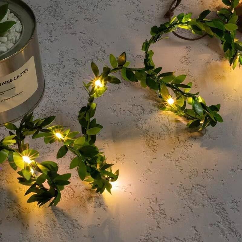 Decorative green vine with small lights on a textured surface