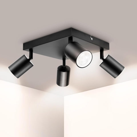 Modern black ceiling light fixture with four adjustable lights on a neutral background