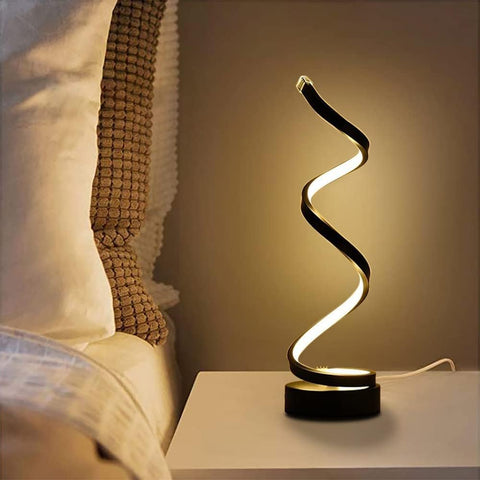 Modern table lamp with wavy design on a bedside table