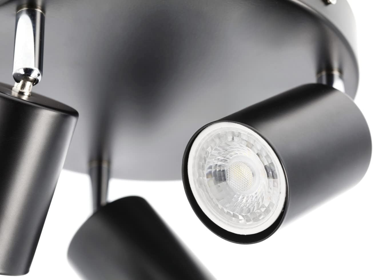 Close-up of a modern ceiling light fixture with three black cylindrical lights.