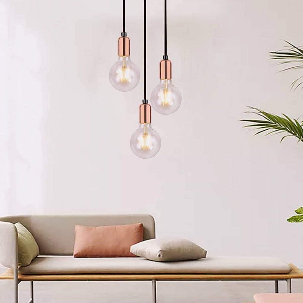 Three pendant lights with copper accents hanging above a sofa in a living room setting.