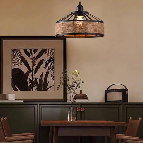 Dining room with pendant light, framed artwork, and wooden table.