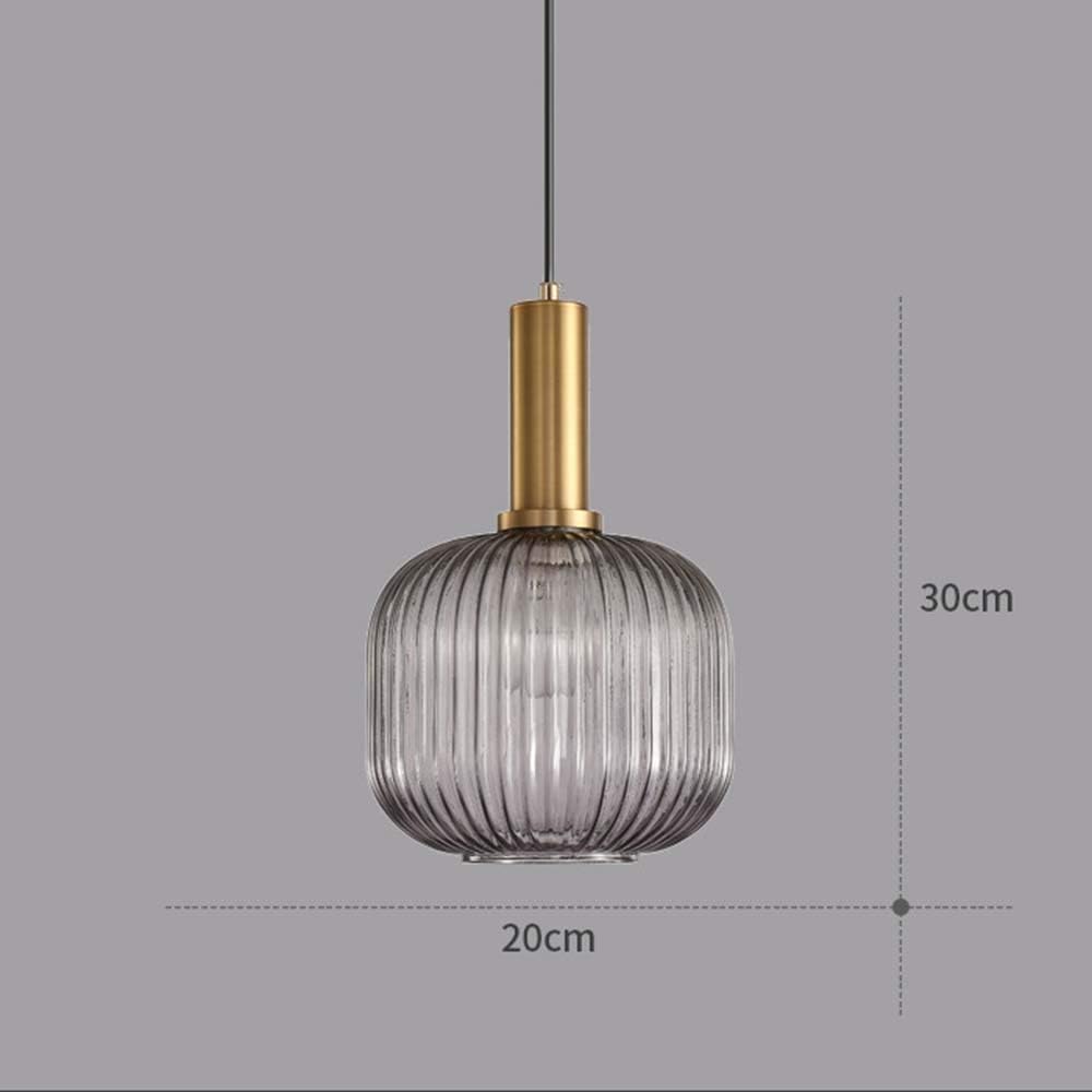 Pendant light with ribbed glass shade and gold fixture on a gray background