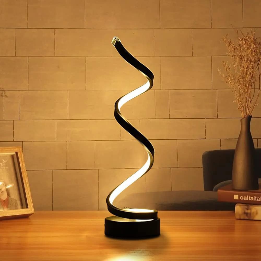 Spiral table lamp on a wooden surface with a warm-toned wall in the background