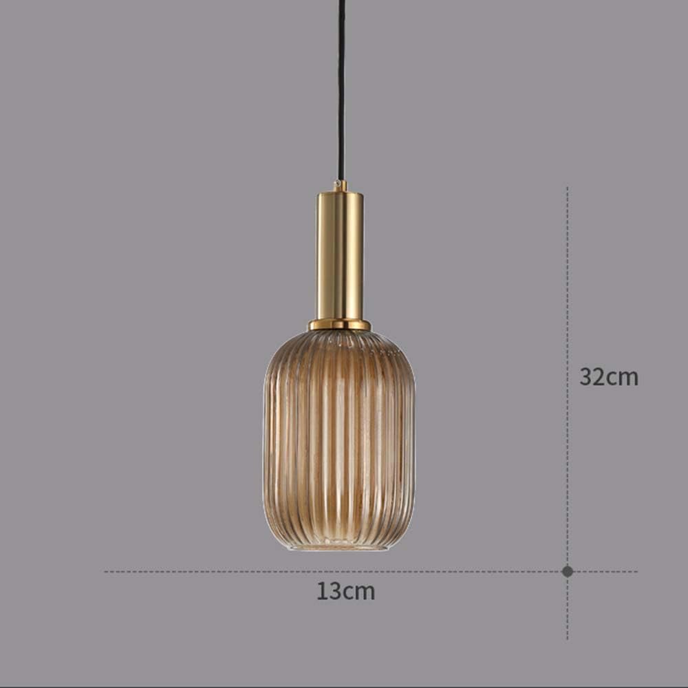 Pendant light with ribbed glass shade and gold fixture on a gray background