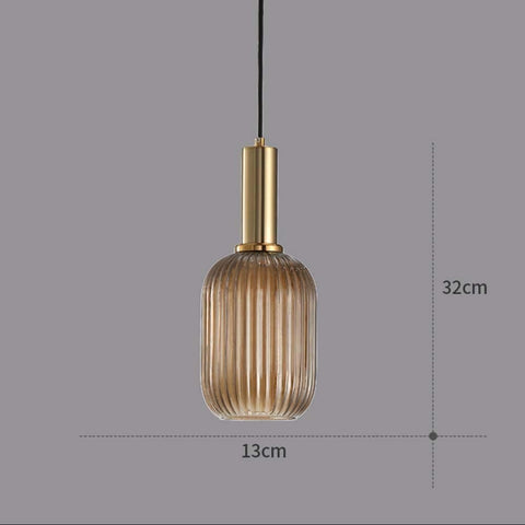 Pendant light with ribbed glass shade and gold fixture on a gray background
