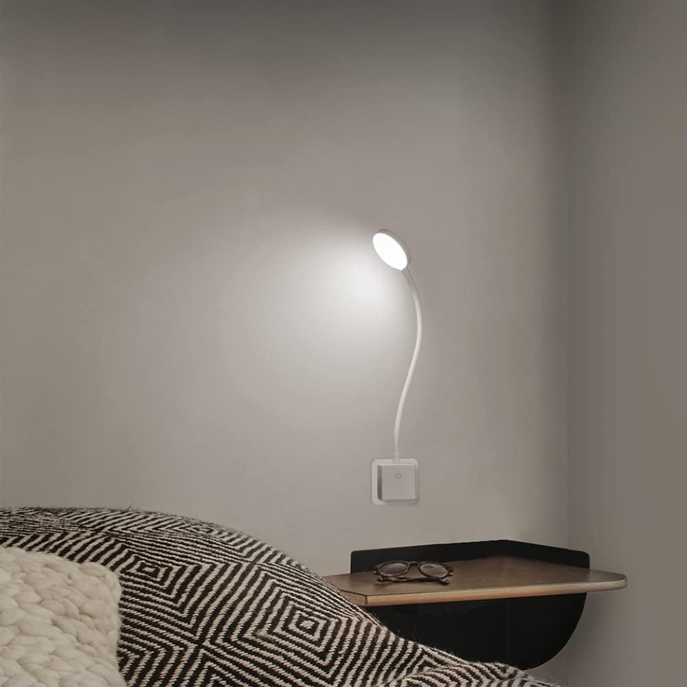 Wall-mounted lamp on a nightstand next to a bed with a patterned blanket.