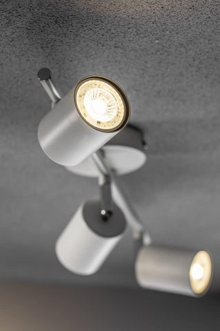 Ceiling light fixture with three cylindrical lights on a gray ceiling.